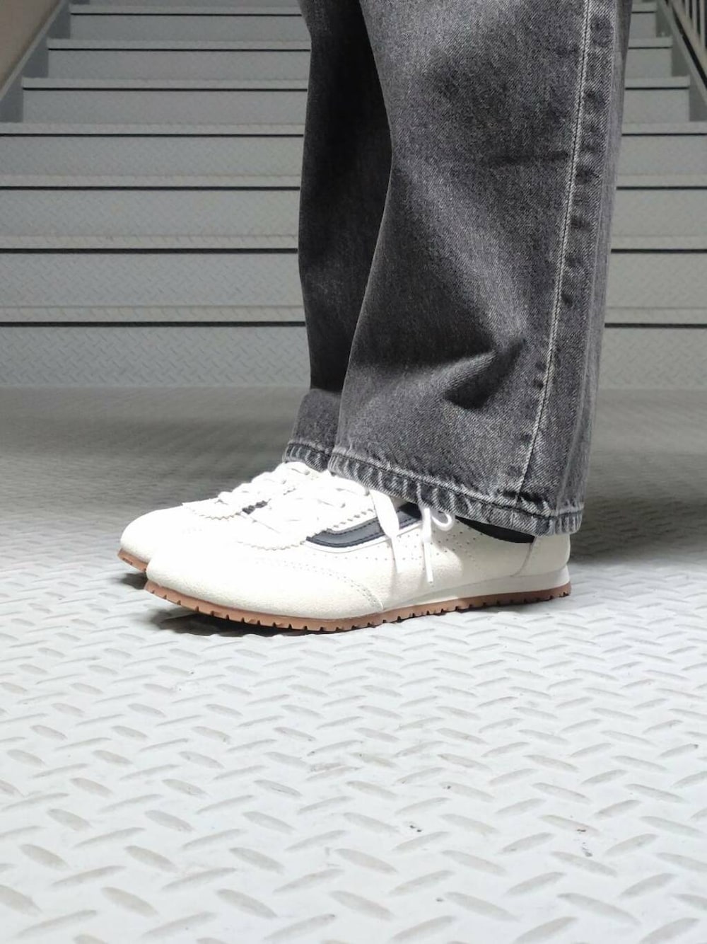 ブラック系のデニムパンツ、ベージュ系のかごバッグ、ホワイト系のシャツ/ブラウスを着用したレディースの春コーディネートの3枚目の写真