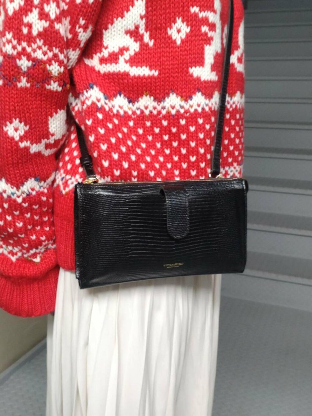 ホワイト系のスカート、レッド系のニット/セーター、ブラック系の財布を着用したレディースの冬コーディネートの3枚目の写真