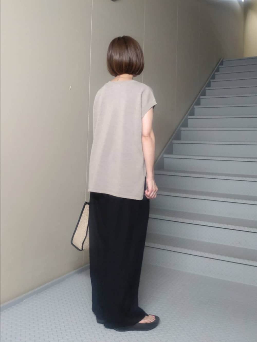 ベージュ系のニット/セーター、ブラック系のその他パンツ、ブラック系のショルダーバッグを着用したレディースの夏コーディネートの2枚目の写真