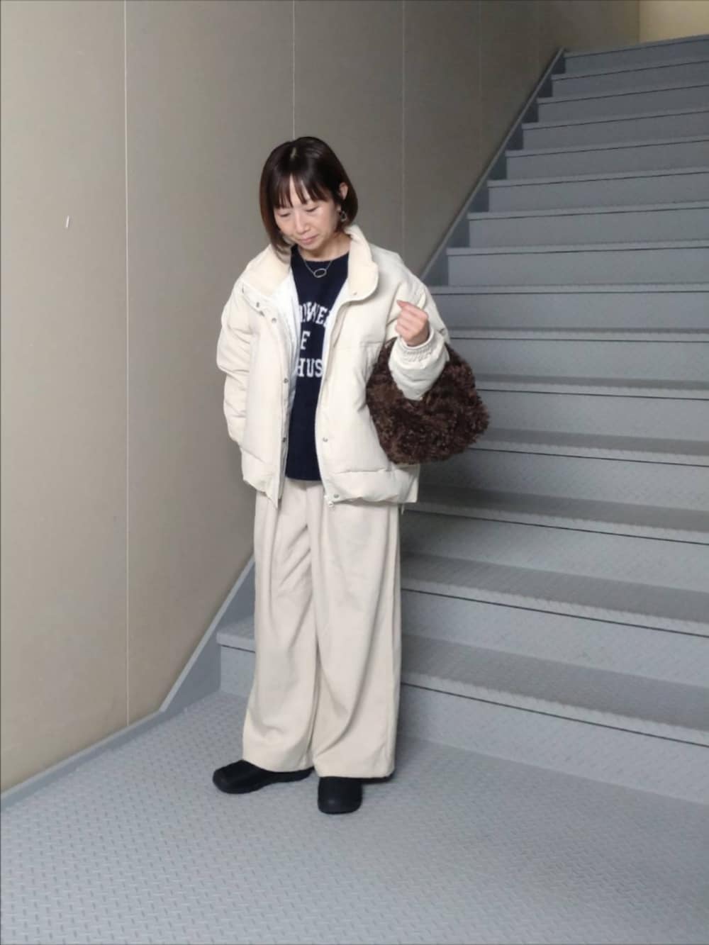 ホワイト系のダウンジャケット/コート、ホワイト系のその他パンツ、ブルー系のニット/セーターを着用したレディースの冬コーディネートの2枚目の写真