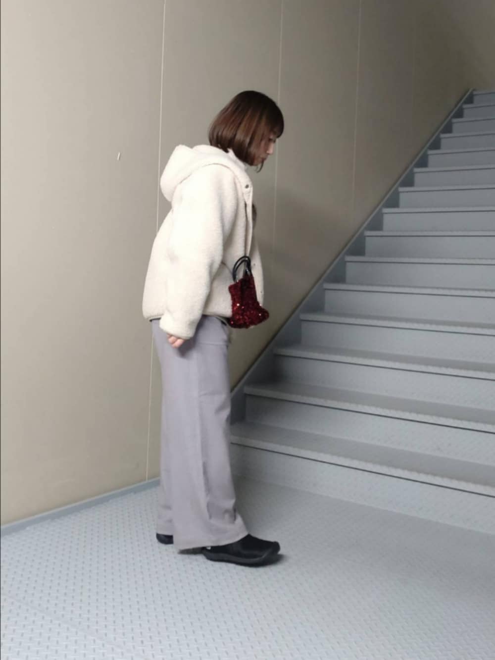 ホワイト系のムートンコート、グレー系のその他パンツ、ホワイト系のスウェットを着用したレディースの冬コーディネートの2枚目の写真