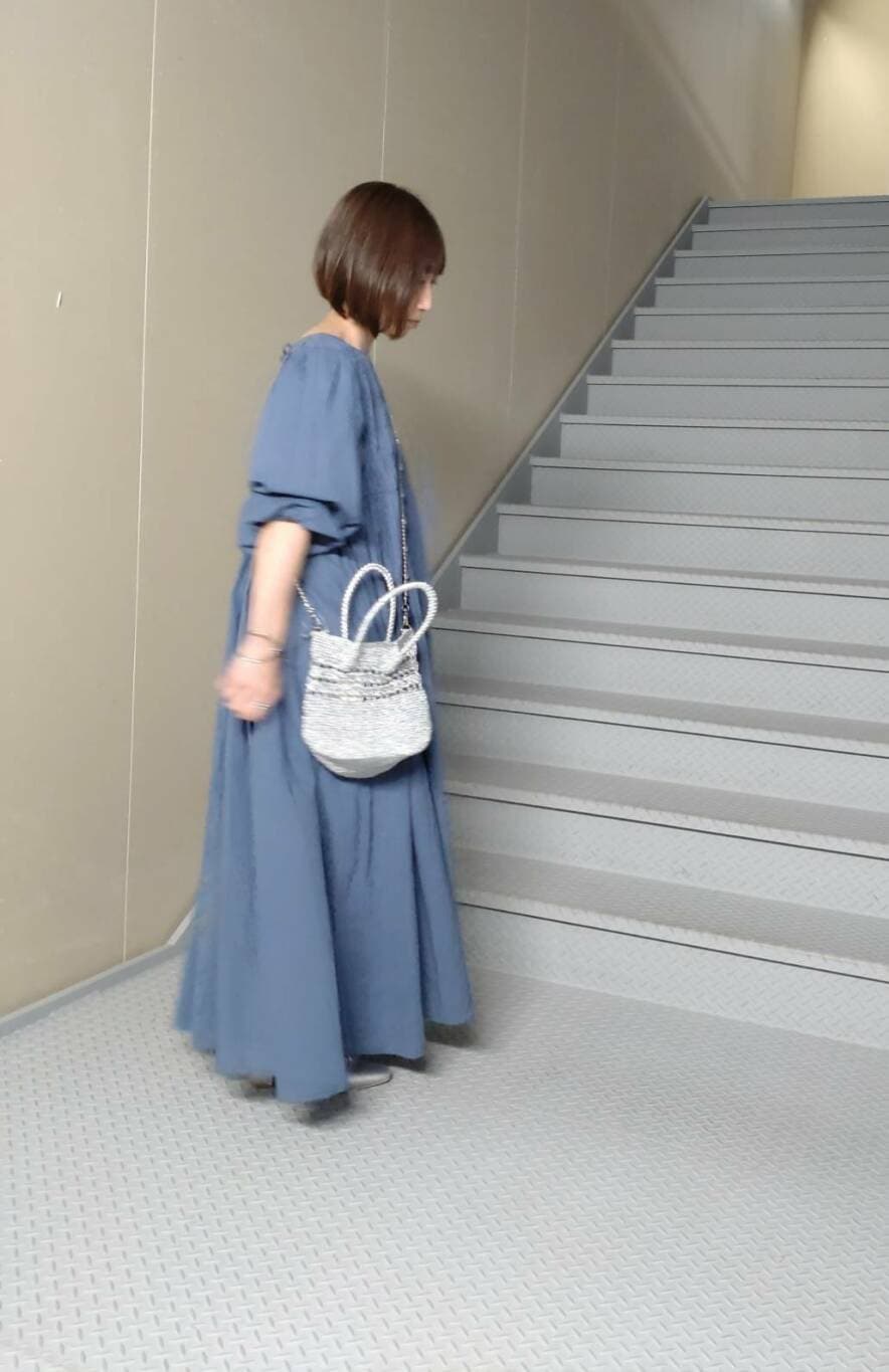 シルバー系のパンプス、シルバー系のショルダーバッグ、ブルー系のワンピースを着用したレディースの春コーディネートの2枚目の写真