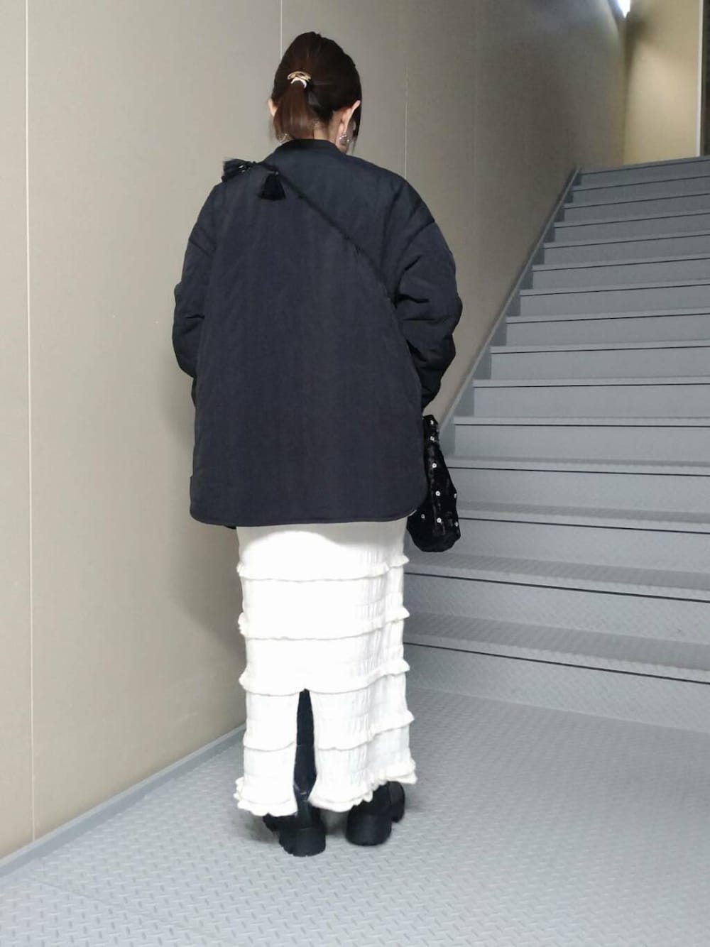 ブラック系のブーツ、ホワイト系のスウェット、ブラック系のブルゾンを着用したレディースの秋コーディネートの2枚目の写真