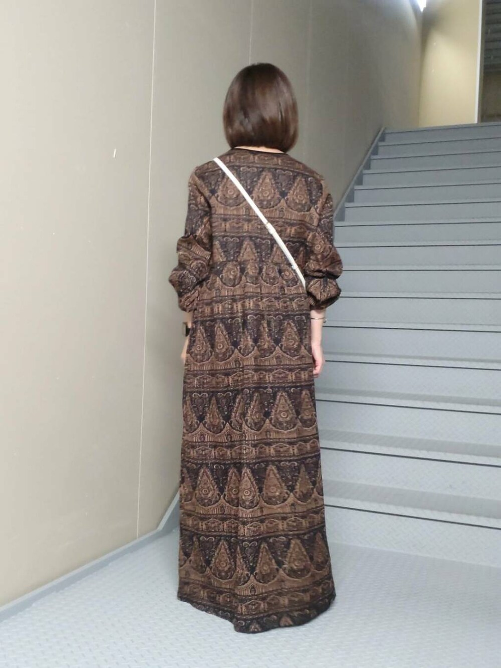 ブラウン系のワンピース、ホワイト系の財布を着用したレディースの秋コーディネートの3枚目の写真