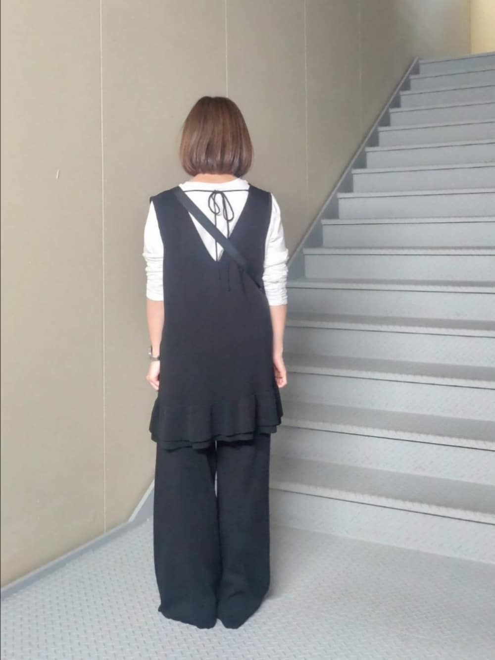 ブルー系のトートバッグ、ホワイト系のTシャツ/カットソー、ブラック系のニット/セーターを着用したレディースの冬コーディネートの3枚目の写真