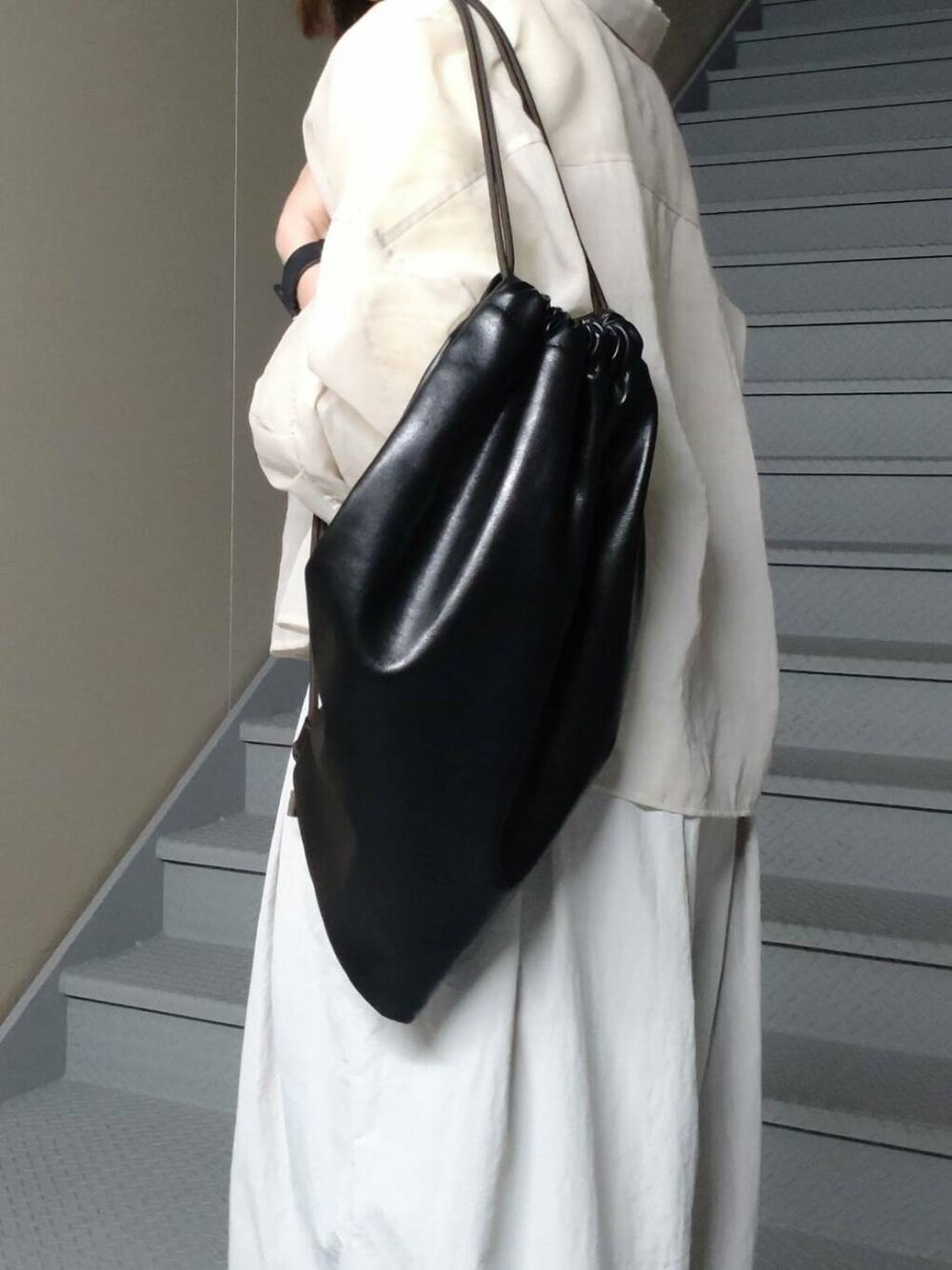 イエロー系のTシャツ/カットソー、ブラック系のバックパック/リュック、グレー系のその他パンツを着用したレディースの春コーディネートの3枚目の写真