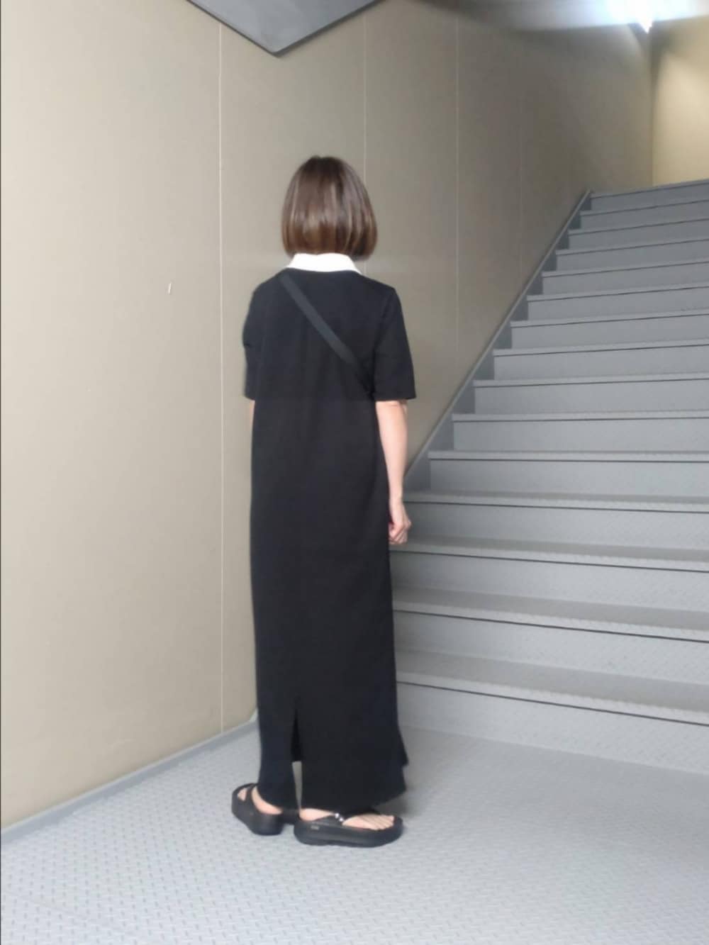 ブラック系のワンピース、ブルー系のトートバッグ、ブラック系のサンダルを着用したレディースの春コーディネートの2枚目の写真