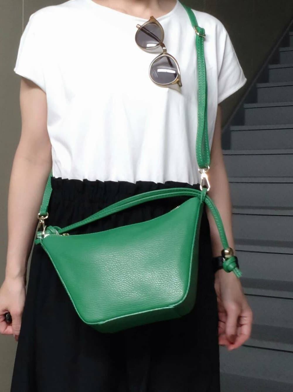 グリーン系のショルダーバッグ、ブラック系のサンダル、ブラック系のワンピースを着用したレディースの夏コーディネートの3枚目の写真