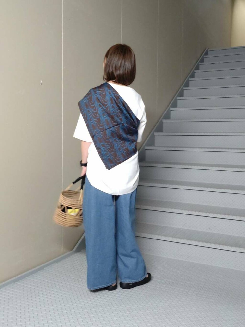 ブラック系のサンダル、ブルー系のデニムパンツ、ホワイト系のTシャツ/カットソーを着用したレディースの春コーディネートの2枚目の写真