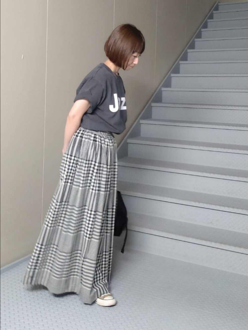 ブラック系のスカート、ブラック系のTシャツ/カットソー、ブラック系のショルダーバッグを着用したレディースの秋コーディネートの2枚目の写真