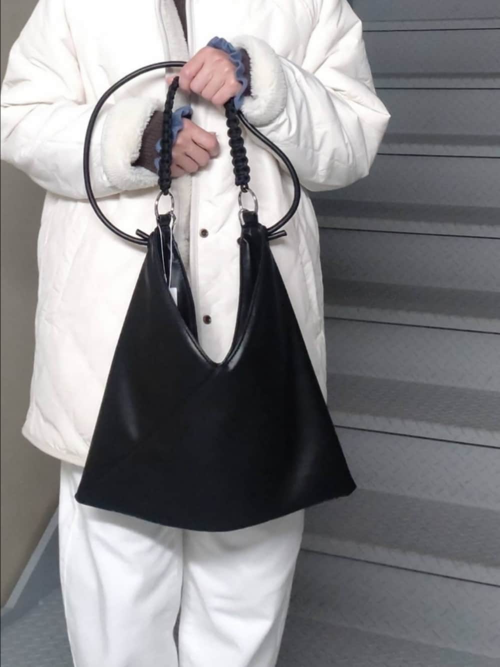 ホワイト系のその他アウター、ホワイト系のデニムパンツ、ブラウン系のニット/セーターを着用したレディースの秋コーディネートの2枚目の写真