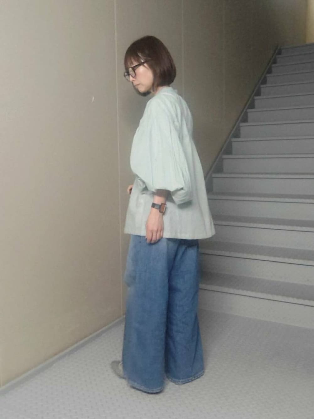 ブルー系のデニムパンツ、グリーン系のシャツ/ブラウス、ホワイト系の財布を着用したレディースの春コーディネートの2枚目の写真