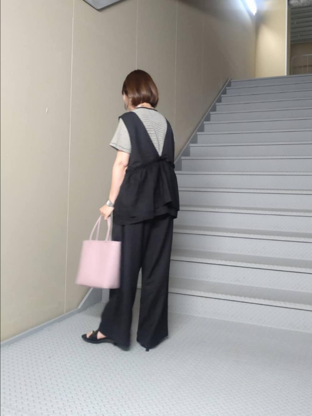 ブラック系のその他パンツ、ブラック系のTシャツ/カットソー、ブラック系のサンダルを着用したレディースの春コーディネートの2枚目の写真