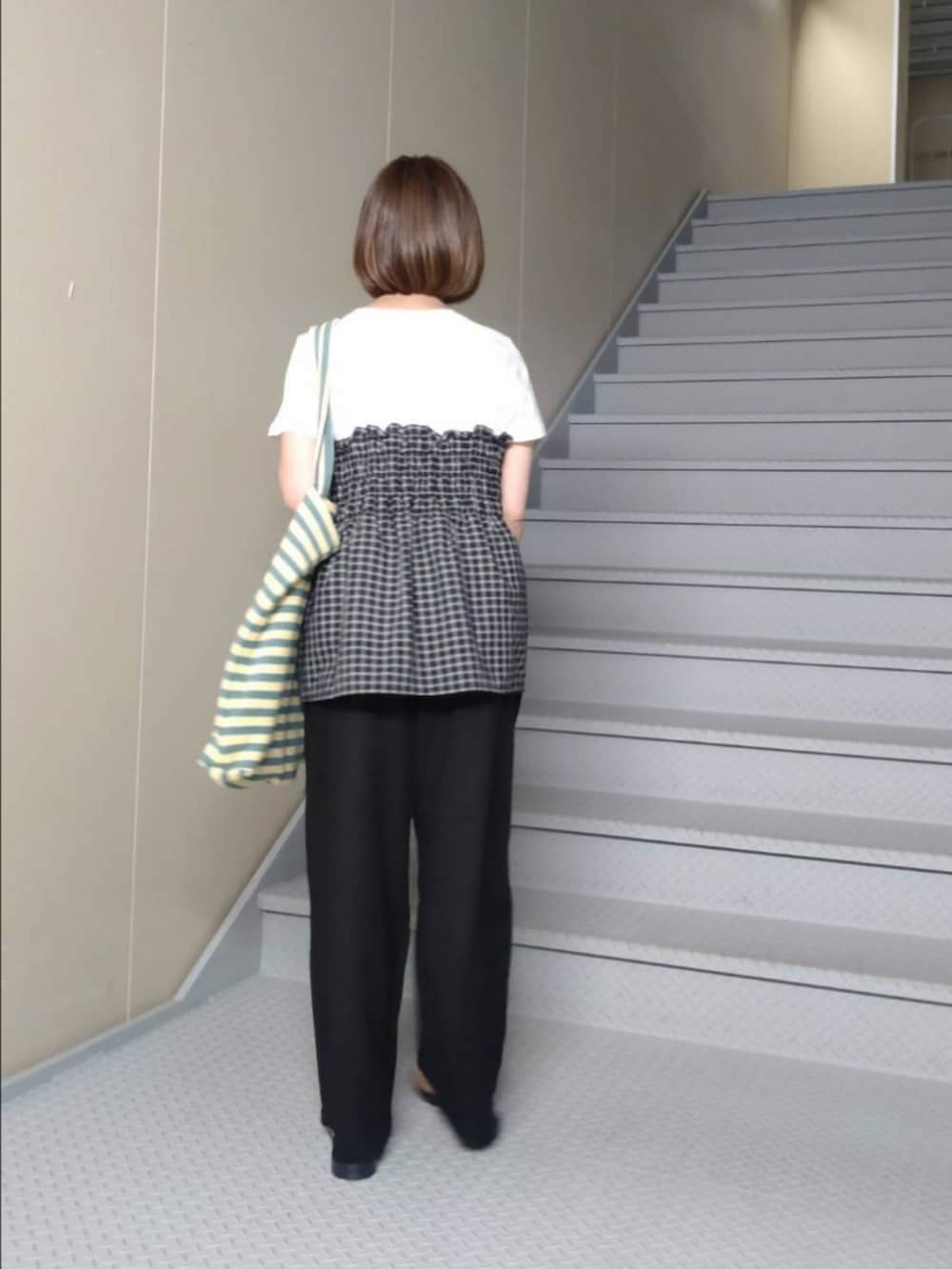 ブラック系のTシャツ/カットソー、ブラック系のその他パンツ、グリーン系のトートバッグを着用したレディースの夏コーディネートの2枚目の写真