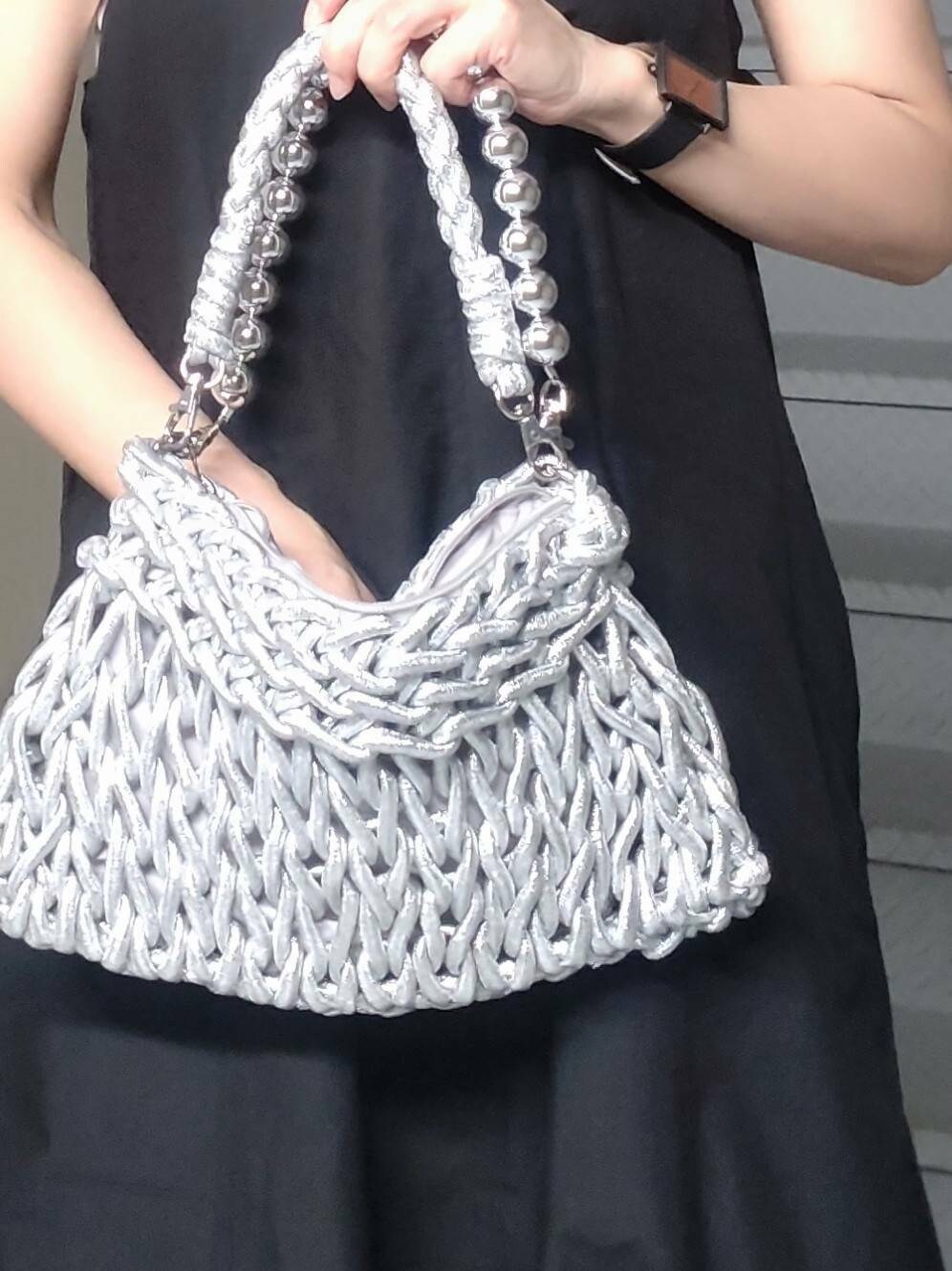 シルバー系のハンドバッグ、ホワイト系のタンクトップ、ブラック系のワンピースを着用したレディースの夏コーディネートの4枚目の写真