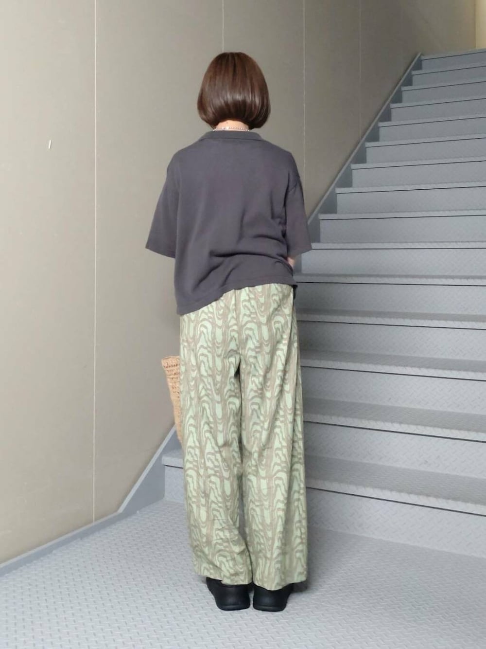 ベージュ系のトートバッグ、グレー系のニット/セーター、ホワイト系のTシャツ/カットソーを着用したレディースの春コーディネートの3枚目の写真