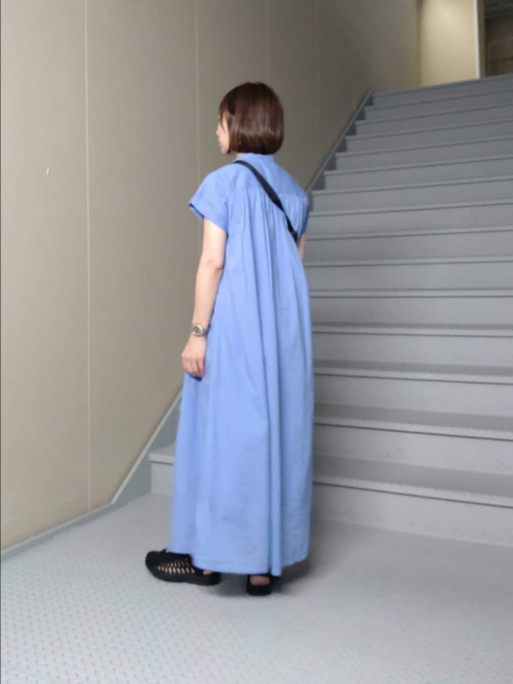 ブルー系のワンピース、ブラック系のショルダーバッグを着用したレディースの夏コーディネートの2枚目の写真