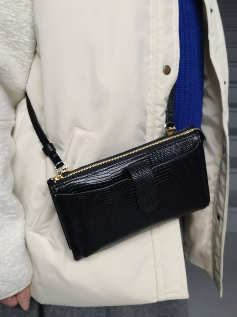 ブラック系のブーツ、ホワイト系のブルゾン、ブルー系のニット/セーターを着用したレディースの冬コーディネートの3枚目の写真