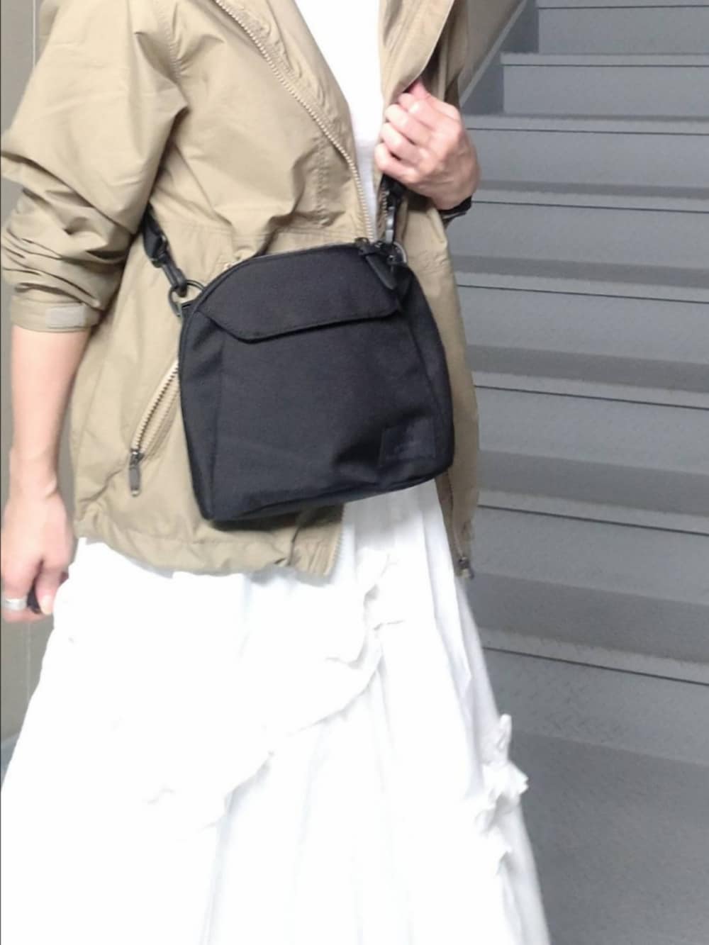 ホワイト系のスカート、グリーン系のナイロンジャケット、ホワイト系のTシャツ/カットソーを着用したレディースの秋コーディネートの4枚目の写真