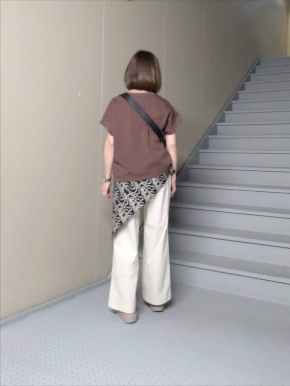 ホワイト系のその他パンツ、ブラウン系のTシャツ/カットソー、ブラック系のショルダーバッグを着用したレディースの春コーディネートの2枚目の写真