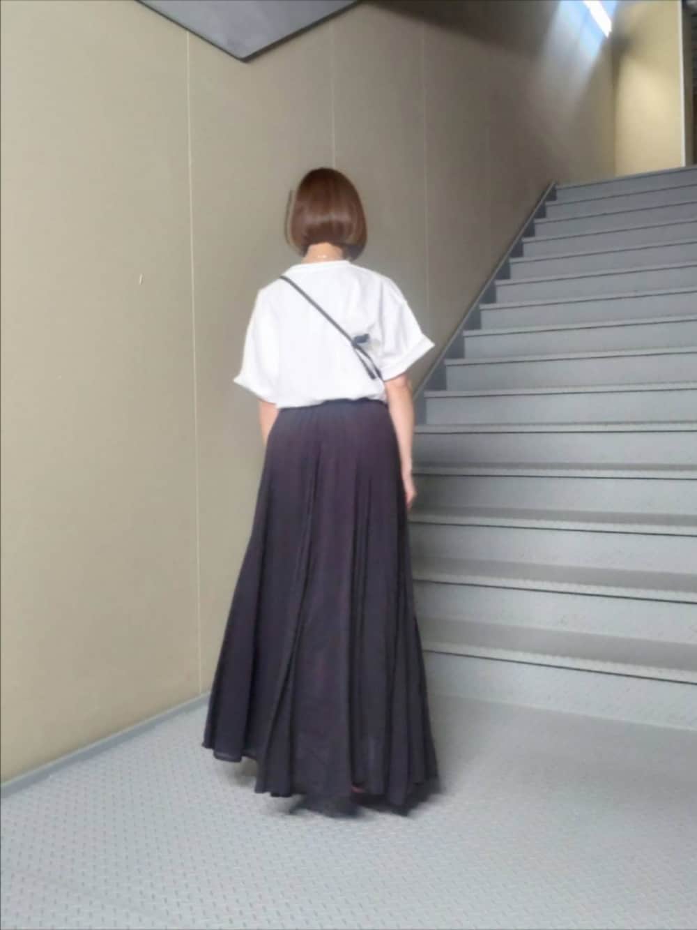 ホワイト系のTシャツ/カットソー、グレー系のスカート、ピンク系のスニーカーを着用したレディースの夏コーディネートの2枚目の写真