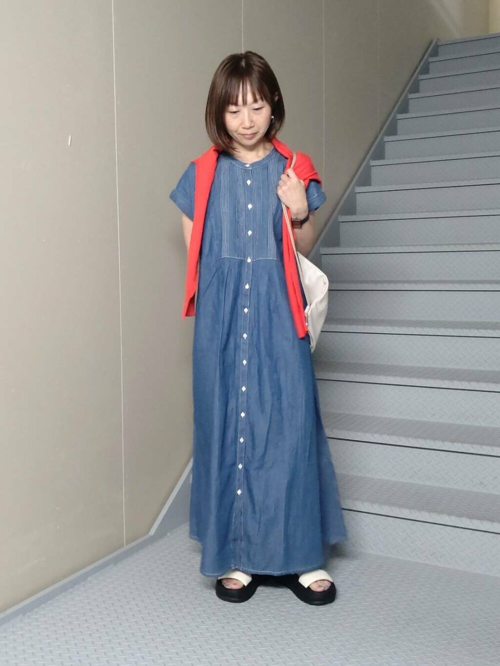 ホワイト系のバックパック/リュック、ブルー系のワンピース、レッド系のカーディガン/ボレロを着用したレディースの春コーディネートの2枚目の写真