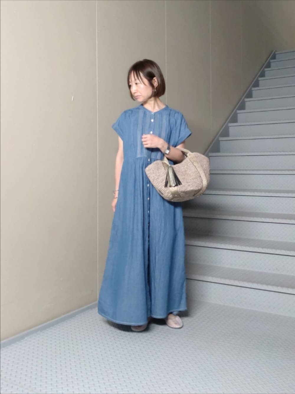 ブルー系のワンピース、ブラウン系のハンドバッグ、その他のバレエシューズを着用したレディースの夏コーディネートの2枚目の写真