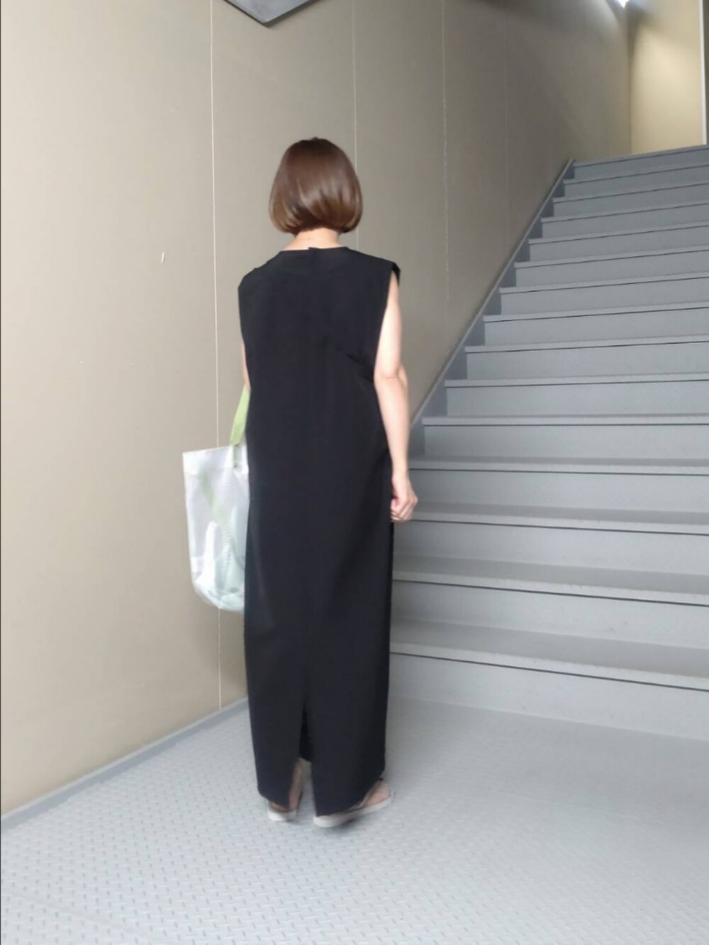 ブラック系のワンピース、その他のトートバッグ、ベージュ系のサングラスを着用したレディースの春コーディネートの2枚目の写真