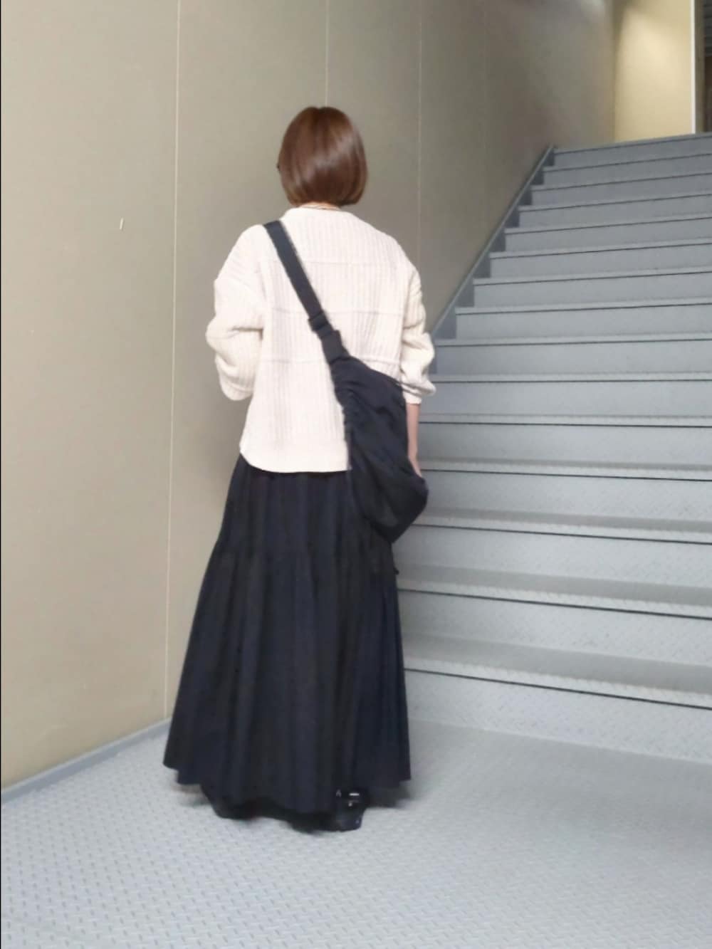 ホワイト系のニット/セーター、ブラック系のスカート、ブラック系のその他雑貨を着用したレディースの秋コーディネートの2枚目の写真