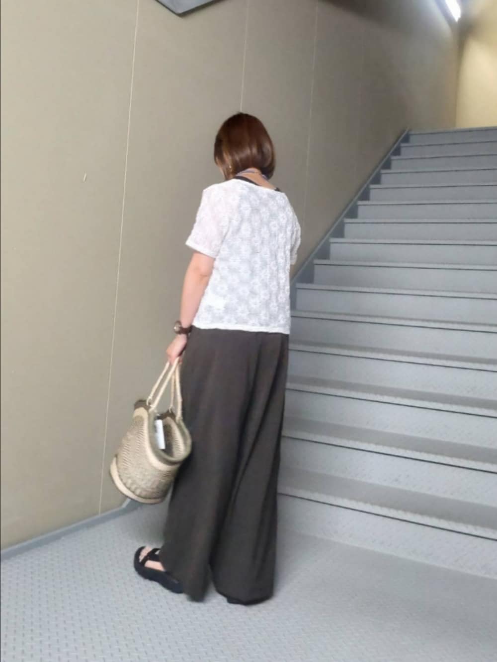 ホワイト系のTシャツ/カットソー、グレー系のその他パンツ、ブラウン系のかごバッグを着用したレディースの夏コーディネートの2枚目の写真