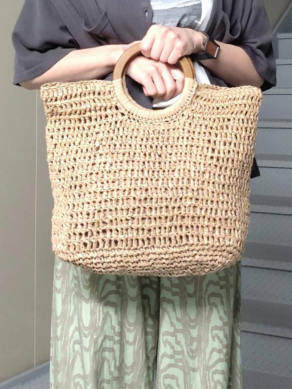 ベージュ系のトートバッグ、グレー系のニット/セーター、ホワイト系のTシャツ/カットソーを着用したレディースの春コーディネートの4枚目の写真