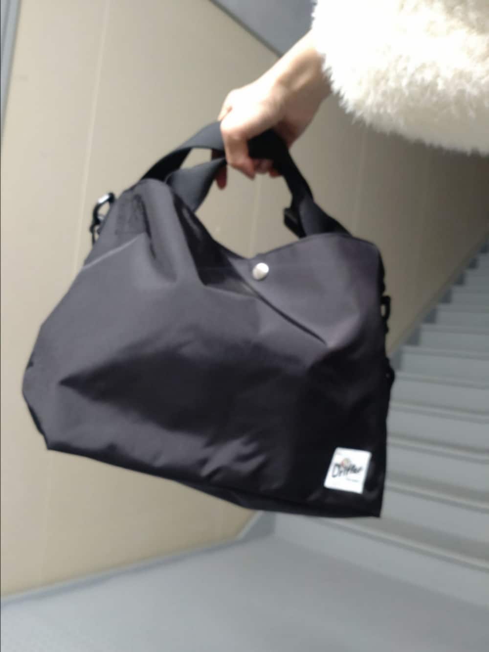 ホワイト系のカーディガン/ボレロ、ブラウン系のスカート、ブラック系のショルダーバッグを着用したレディースの秋コーディネートの3枚目の写真