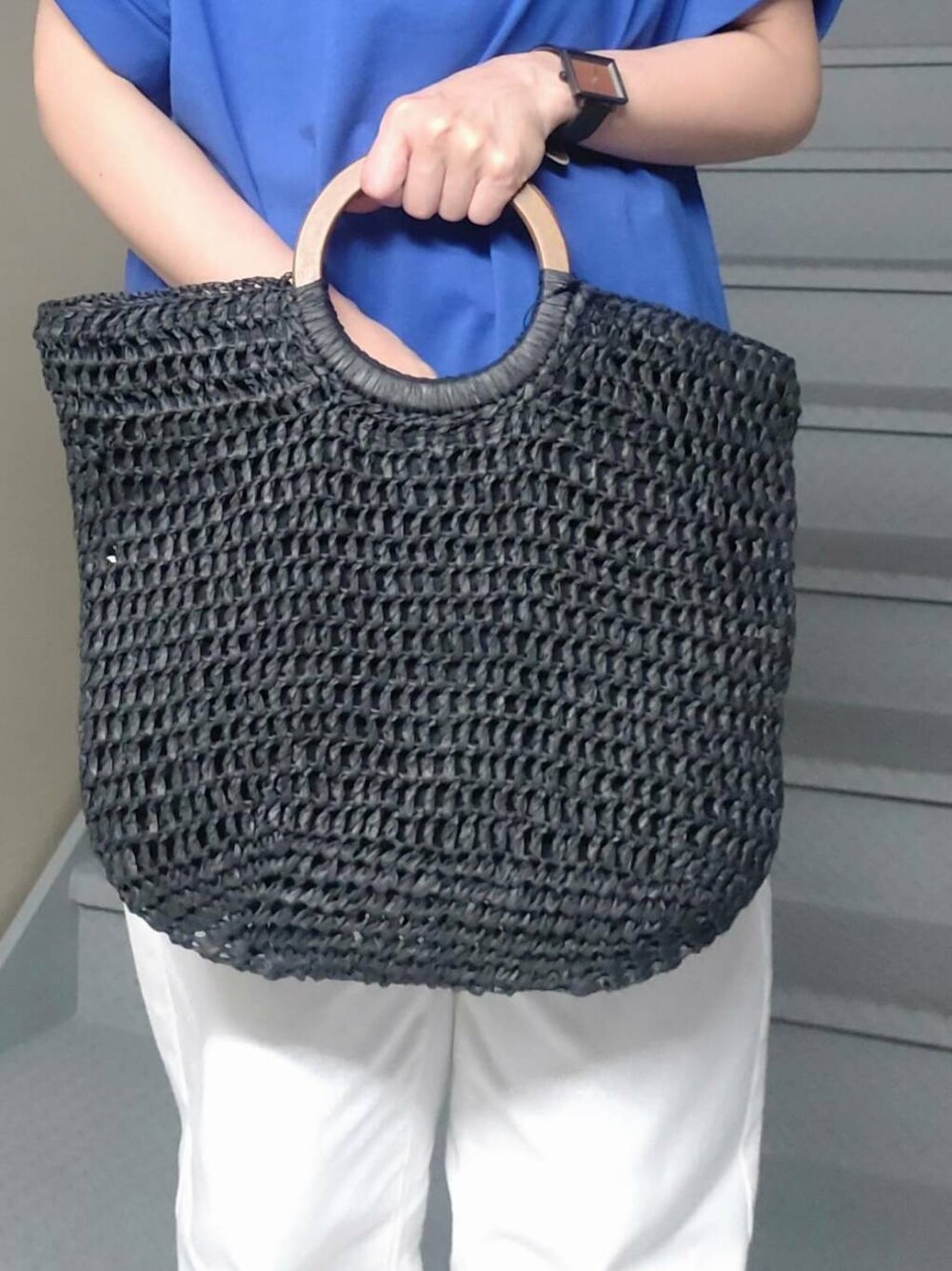 ブラック系のトートバッグ、シルバー系のサンダル、ホワイト系のデニムパンツを着用したレディースの夏コーディネートの4枚目の写真