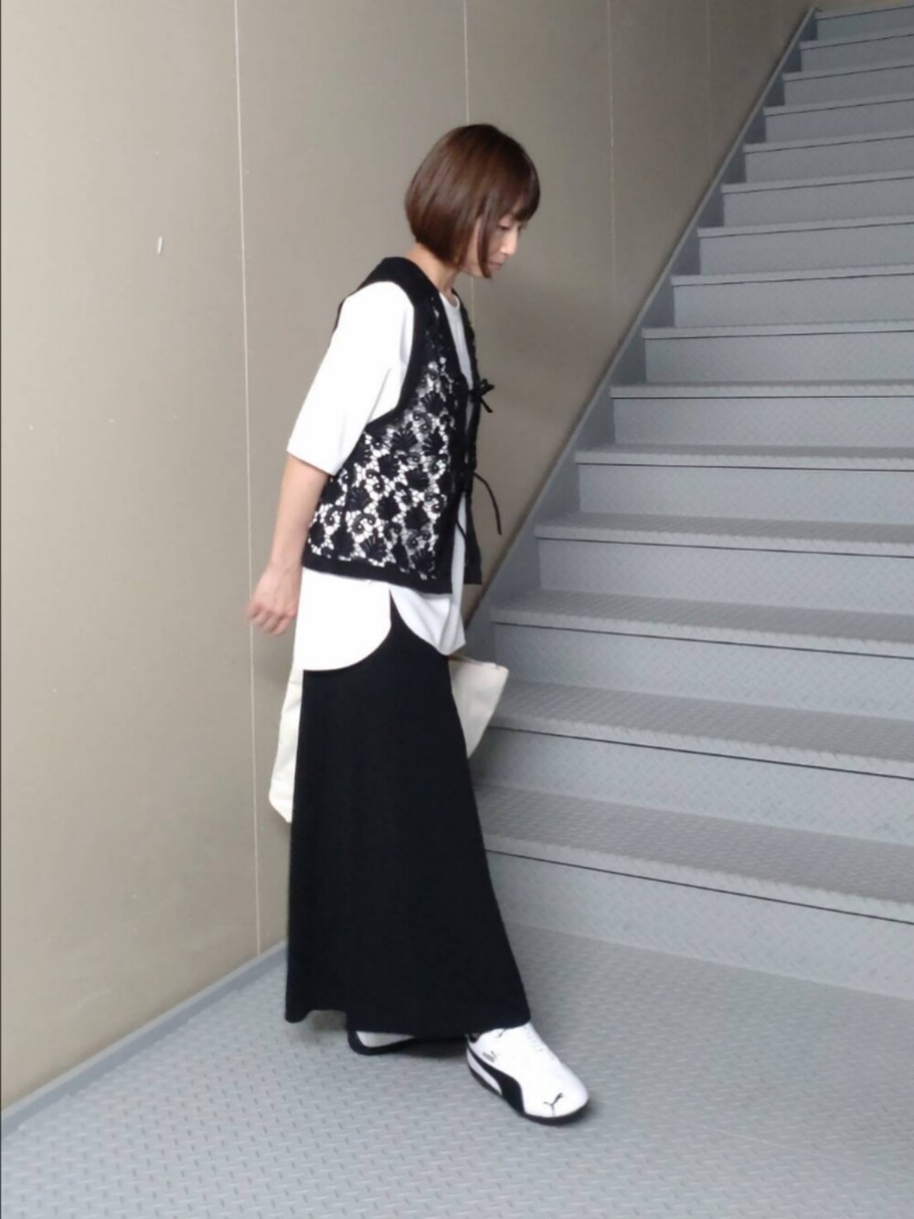 ホワイト系のTシャツ/カットソー、ブラック系のベスト、ホワイト系のスニーカーを着用したレディースの秋コーディネートの2枚目の写真