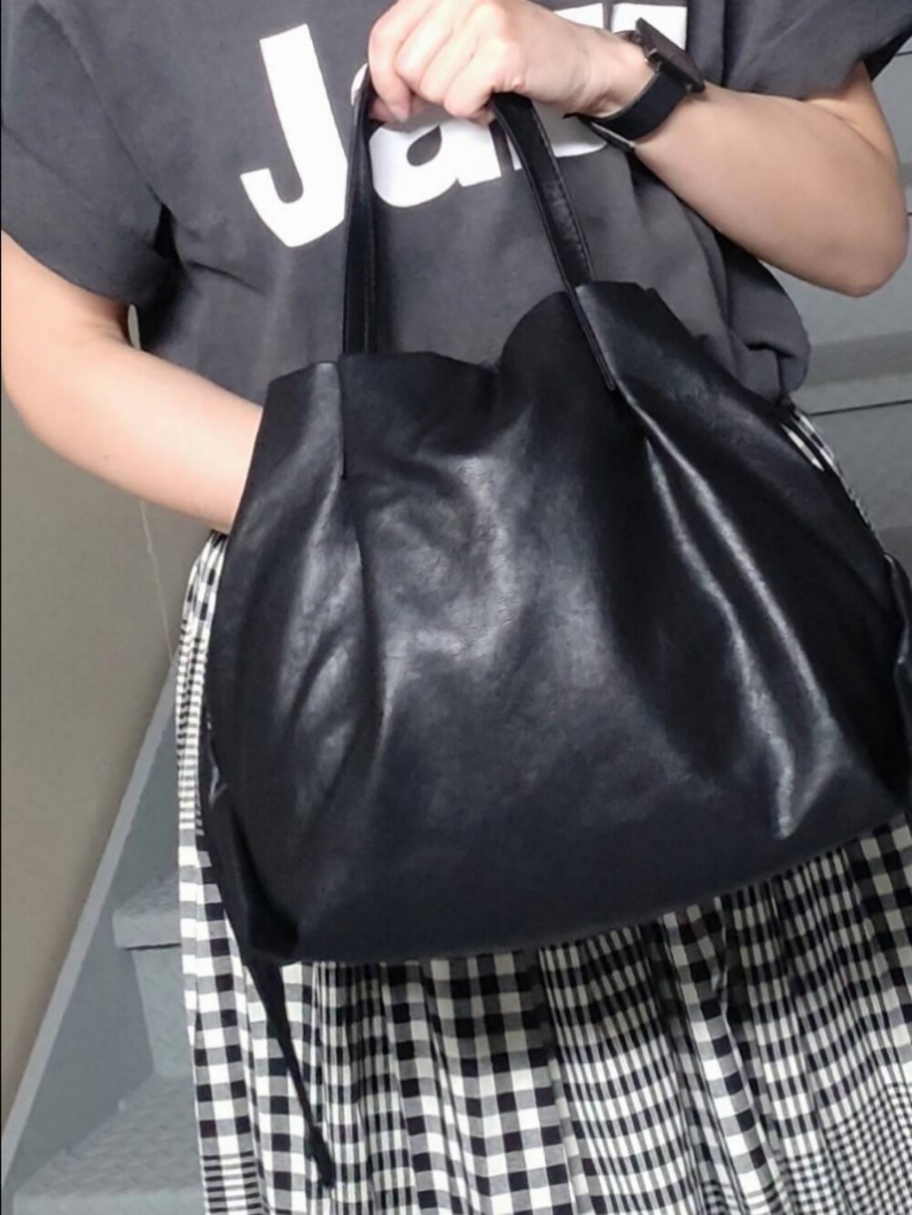 ブラック系のスカート、ブラック系のTシャツ/カットソー、ブラック系のショルダーバッグを着用したレディースの秋コーディネートの3枚目の写真