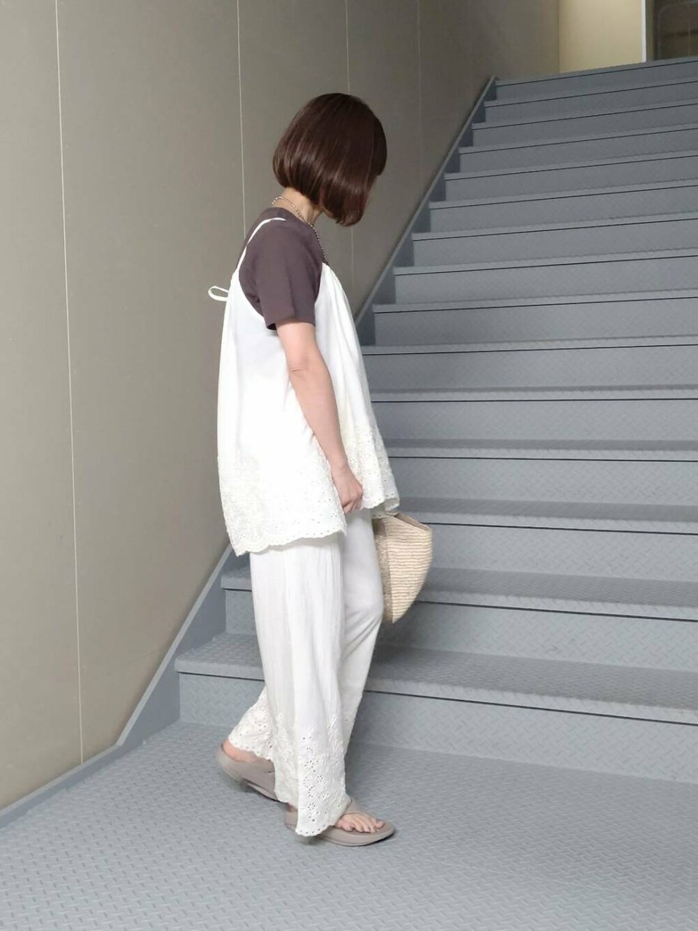 ゴールド系のかごバッグ、ベージュ系のサンダル、ブラウン系のTシャツ/カットソーを着用したレディースの春コーディネートの3枚目の写真