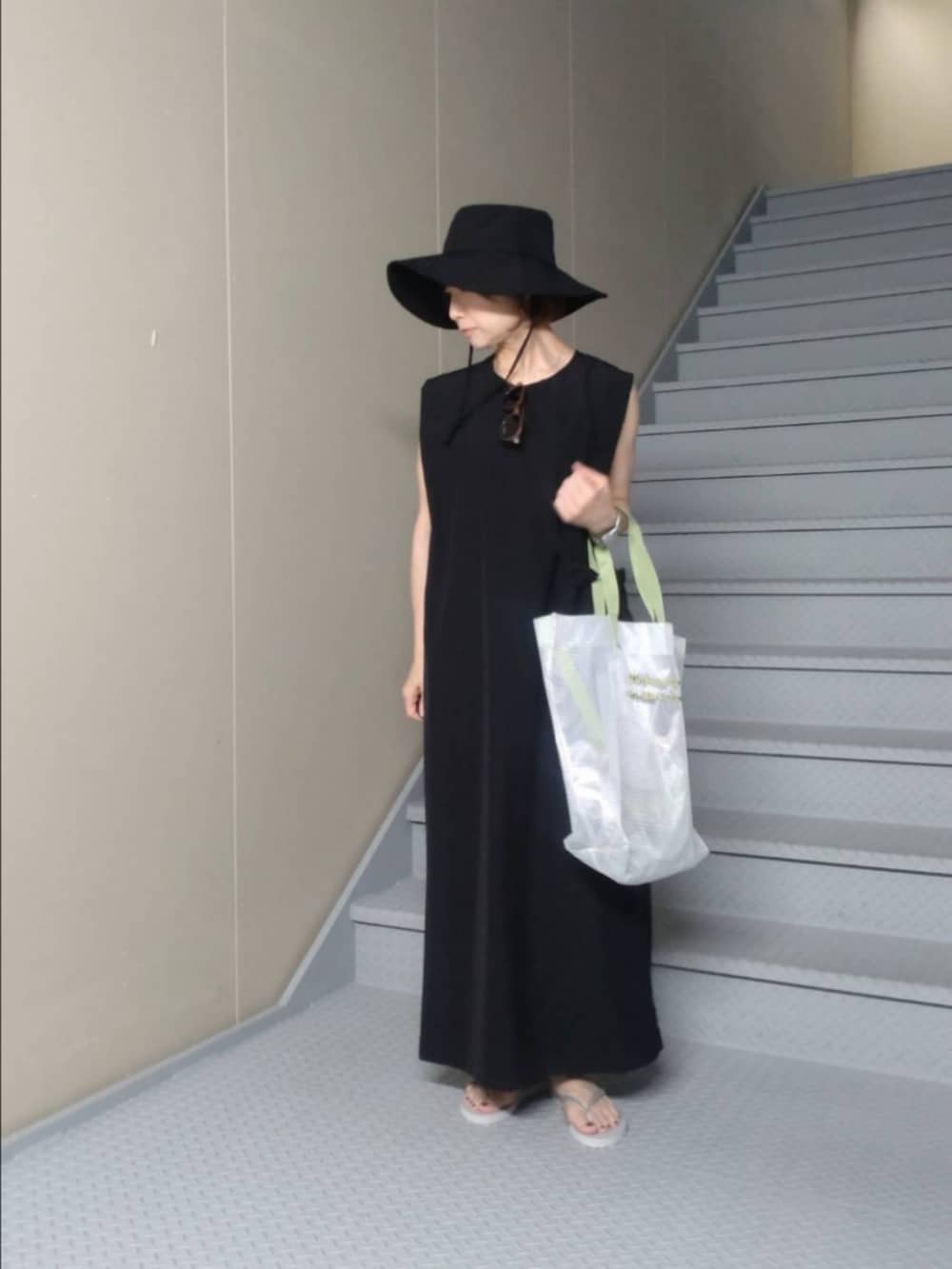 ブラック系のワンピース、その他のトートバッグ、ベージュ系のサングラスを着用したレディースの春コーディネートの3枚目の写真