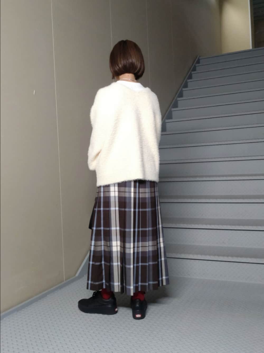 ホワイト系のカーディガン/ボレロ、ブラウン系のスカート、ブラック系のショルダーバッグを着用したレディースの秋コーディネートの2枚目の写真