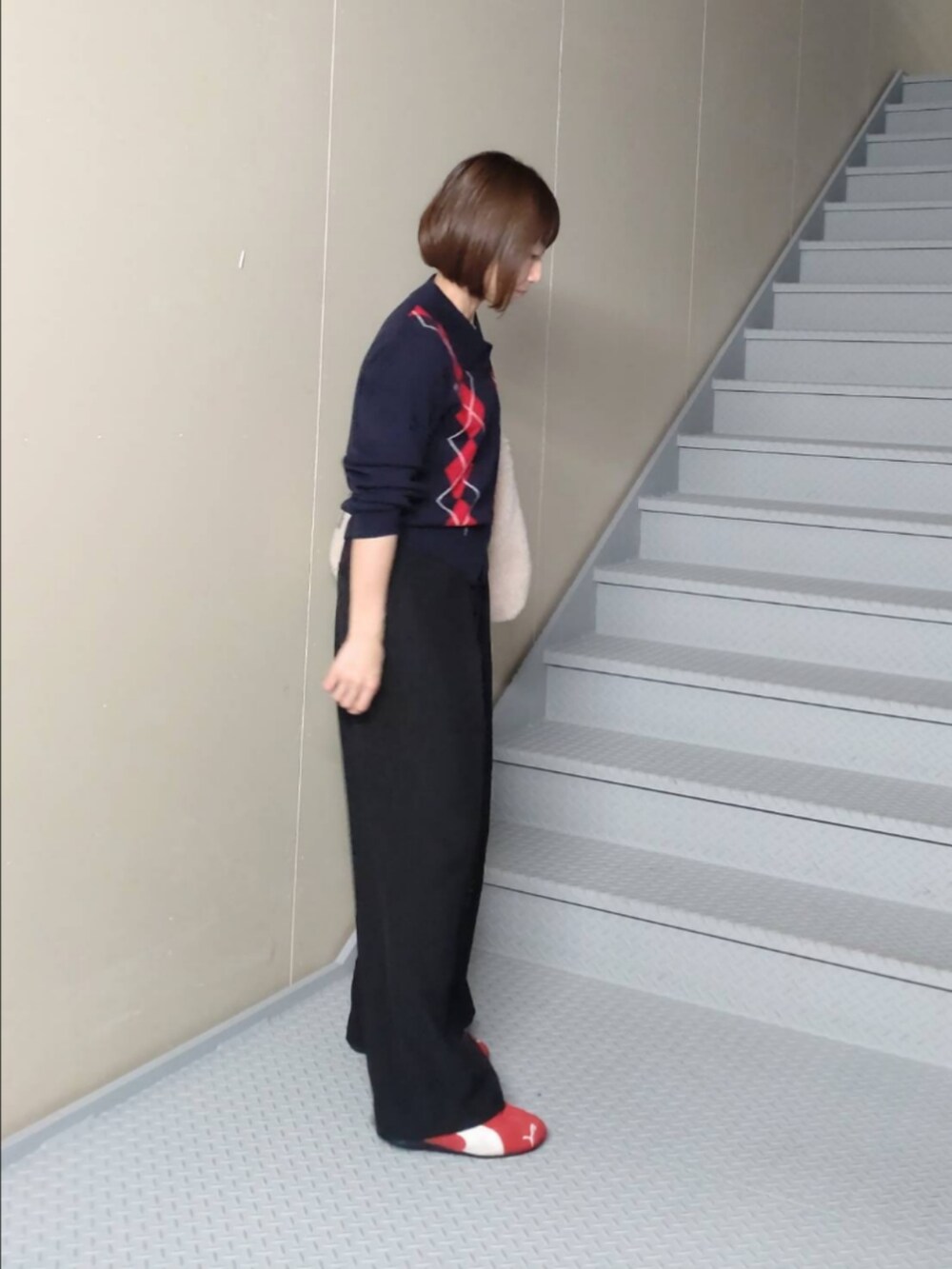 ブラック系のその他パンツ、ホワイト系のショルダーバッグ、レッド系のスニーカーを着用したレディースの秋コーディネートの2枚目の写真