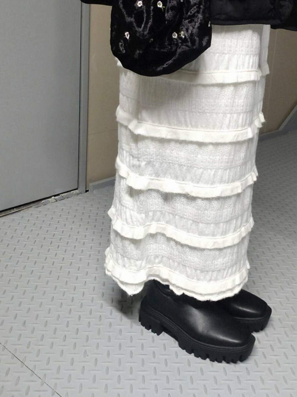 ブラック系のブーツ、ホワイト系のスウェット、ブラック系のブルゾンを着用したレディースの秋コーディネートの3枚目の写真