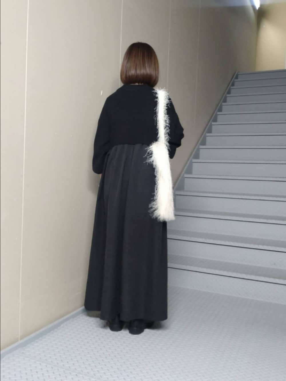 ブラック系のワンピース、ホワイト系のトートバッグを着用したレディースの冬コーディネートの2枚目の写真