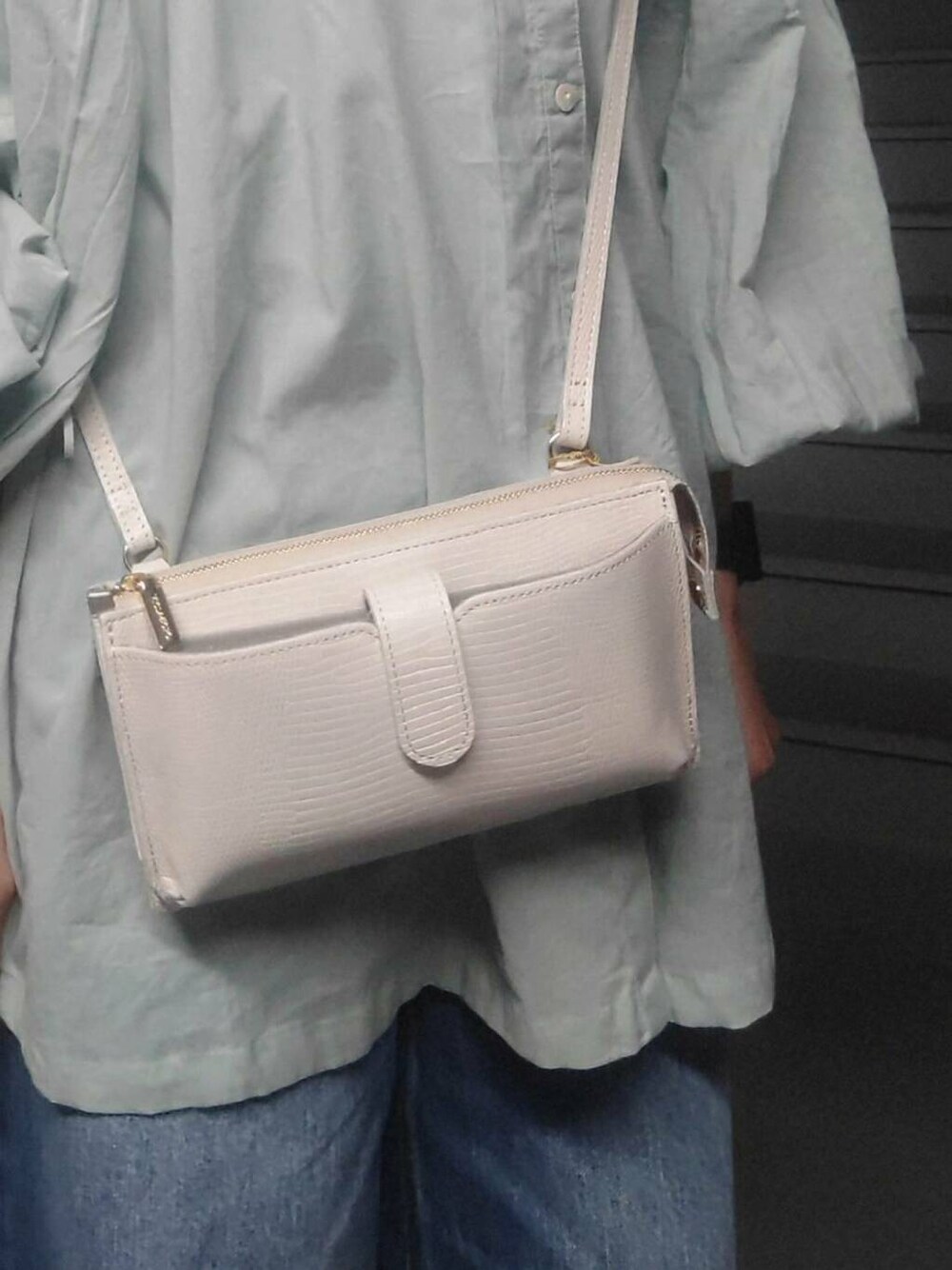 ブルー系のデニムパンツ、グリーン系のシャツ/ブラウス、ホワイト系の財布を着用したレディースの春コーディネートの3枚目の写真