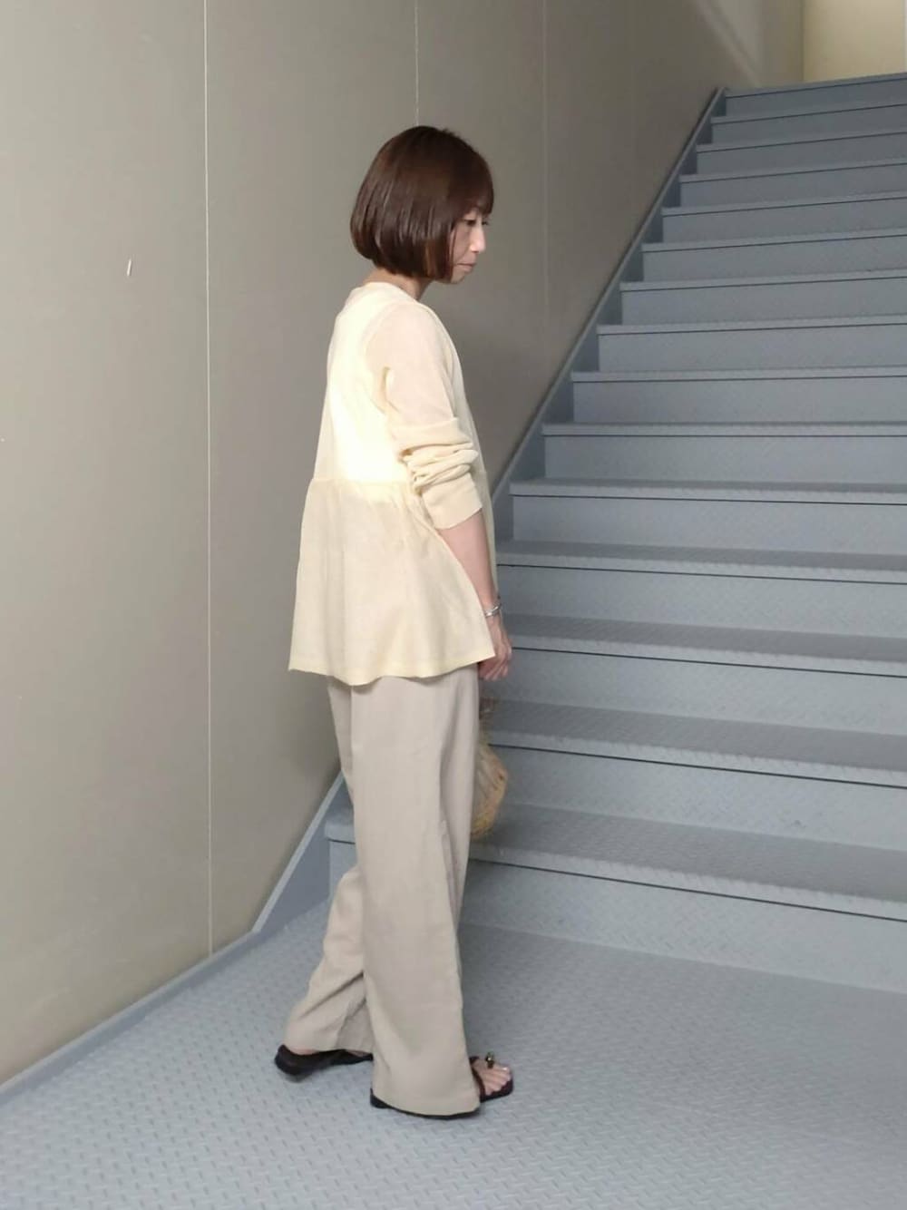 ベージュ系のその他パンツ、ブラウン系のサンダル、イエロー系のカーディガン/ボレロを着用したレディースの夏コーディネートの2枚目の写真