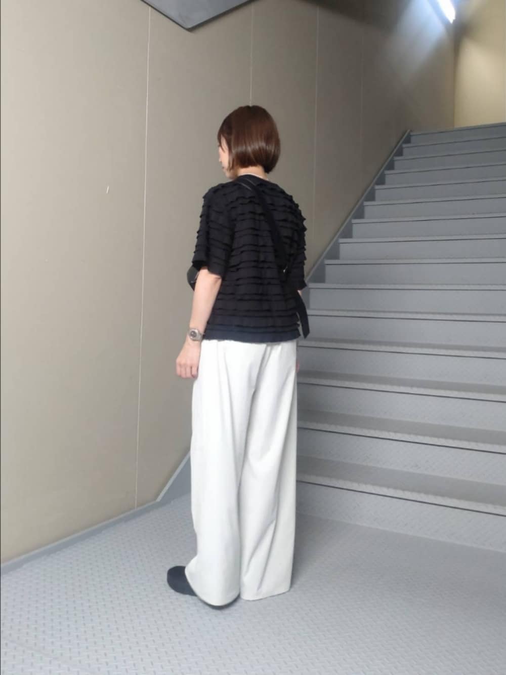 ブラック系のTシャツ/カットソー、グレー系のその他パンツ、ブラック系のショルダーバッグを着用したレディースの夏コーディネートの2枚目の写真