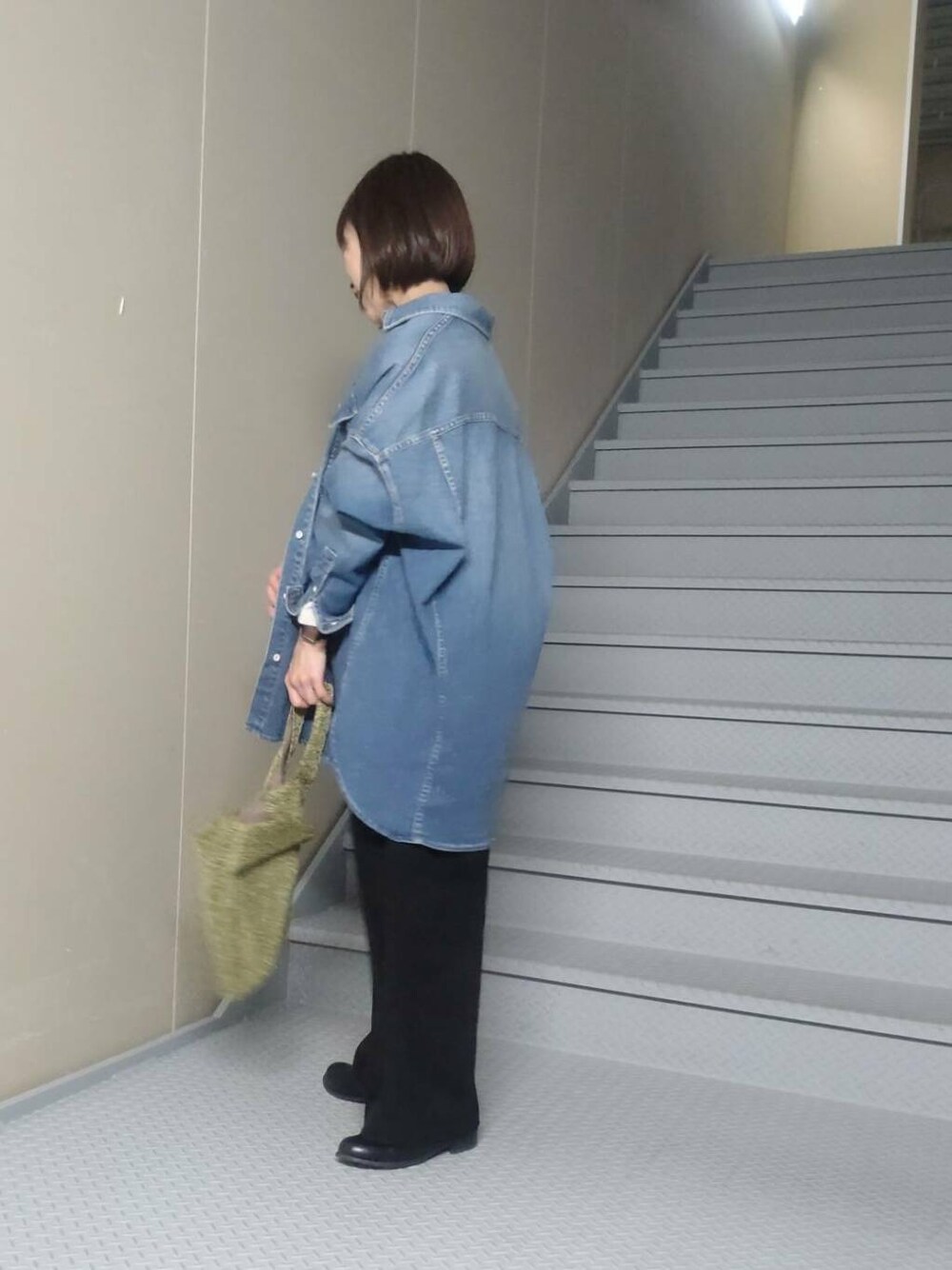 ゴールド系のトートバッグ、ブルー系のシャツ/ブラウス、ベージュ系のスウェットを着用したレディースの冬コーディネートの2枚目の写真
