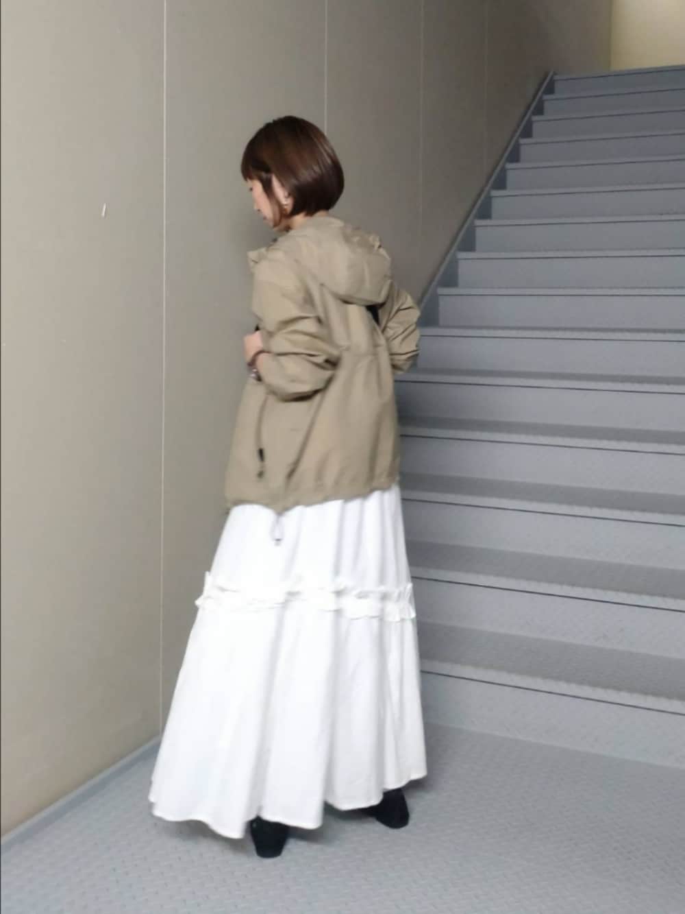 ホワイト系のスカート、グリーン系のナイロンジャケット、ホワイト系のTシャツ/カットソーを着用したレディースの秋コーディネートの3枚目の写真