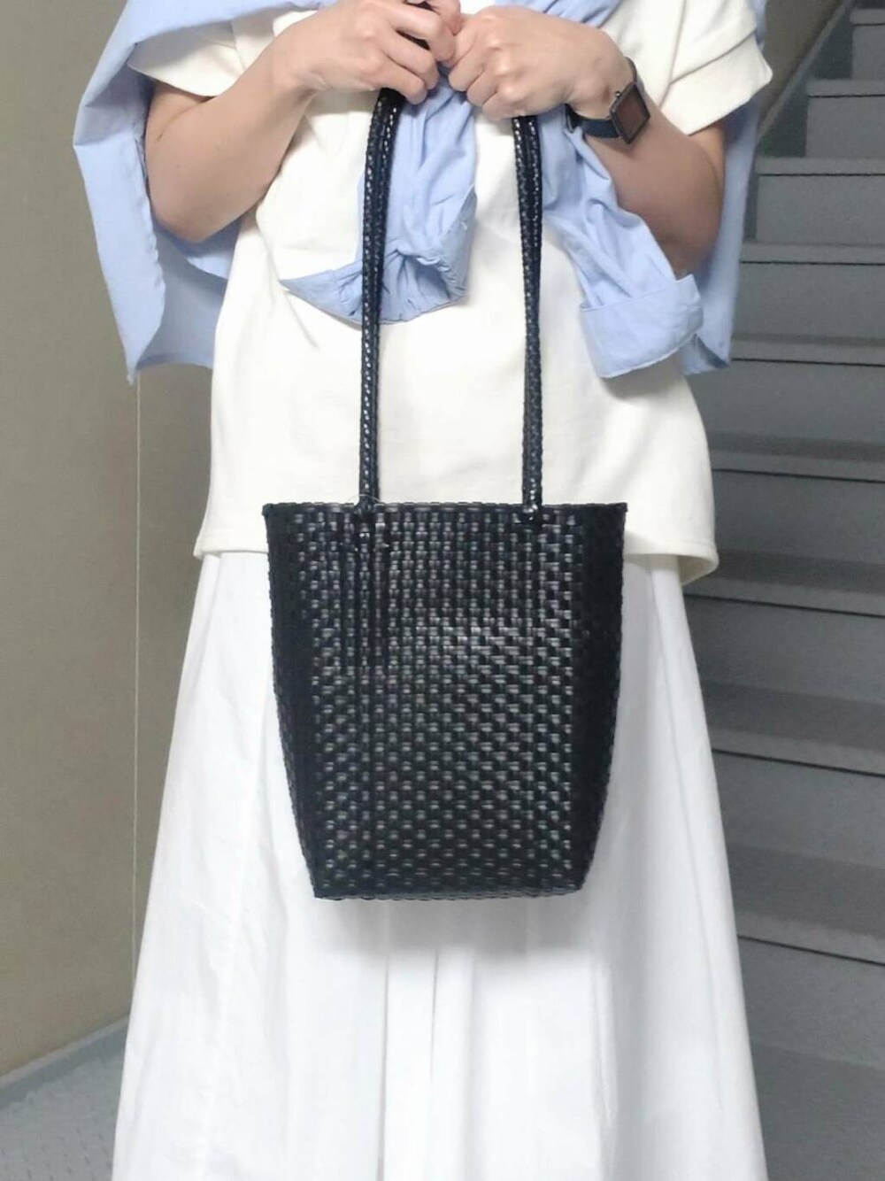 ホワイト系のスカート、ブルー系のシャツ/ブラウス、ブラック系のトートバッグを着用したレディースの春コーディネートの3枚目の写真