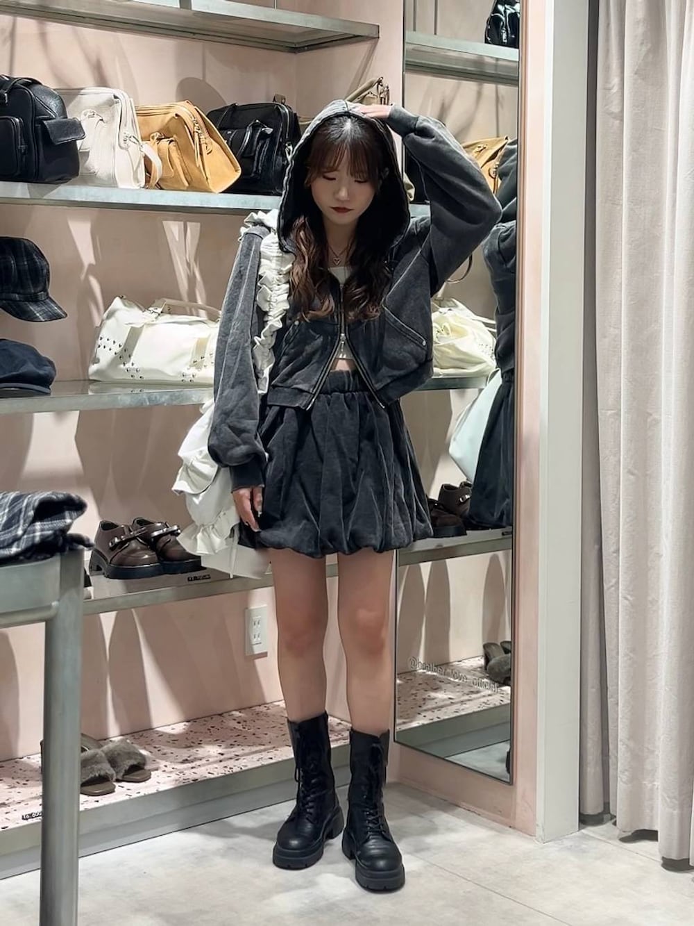 ホワイト系のキャミソール、ブラック系のスカート、ブラック系のパーカーを着用したレディースの秋コーディネートの3枚目の写真