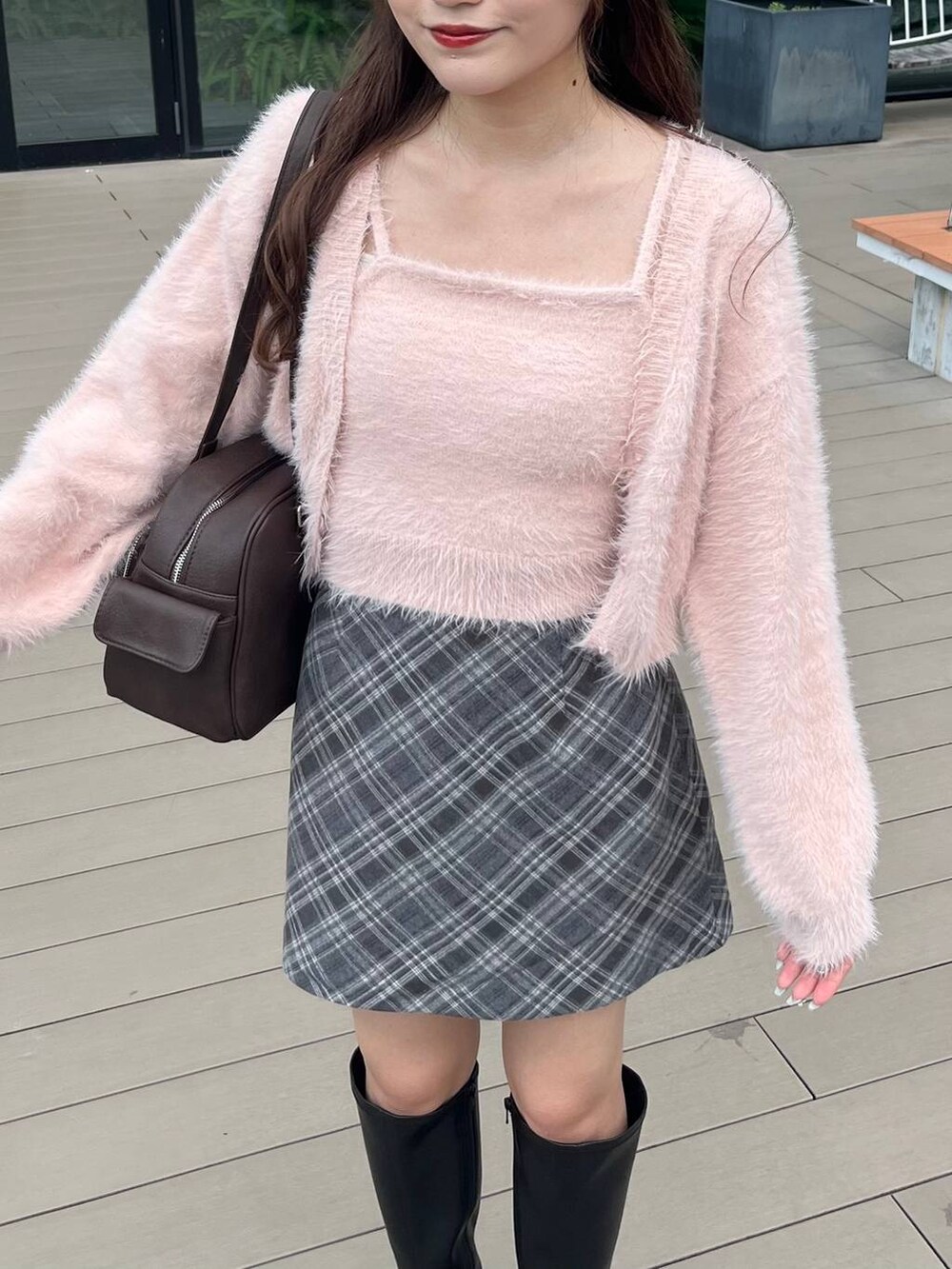 ブラック系のブーツ、グレー系のスカート、ブラウン系のボストンバッグを着用したレディースの秋コーディネートの5枚目の写真