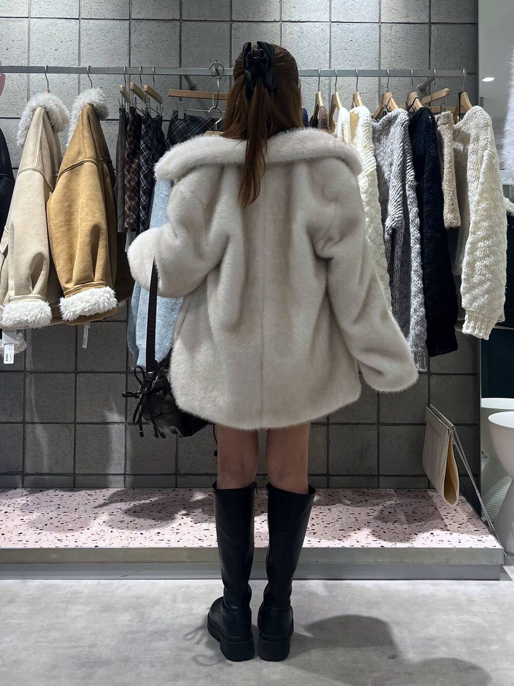 ブラック系のブーツ、ブラック系のスカート、ブラック系のショルダーバッグを着用したレディースの冬コーディネートの5枚目の写真